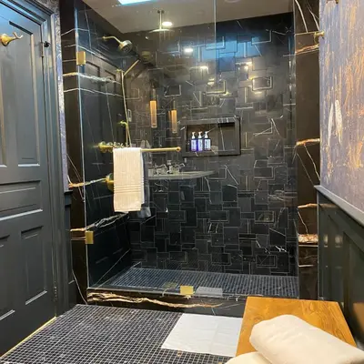 a bathroom with a shower with a black tiled wall at Hattan House Boutique Hotel Bed & Breakfast in Niagara on the Lake