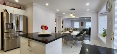 a kitchen and living room with a table and a dining room at Modern Cozy Nook in Brampton