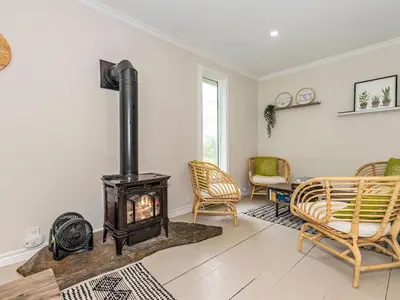 a living room with a wood stove and chairs at Lakefront Muskoka Cottage with Fire Pit and BBQ in Port Carling