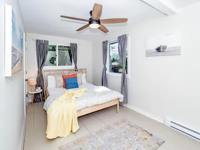 a bedroom with a bed and a ceiling fan at Lakefront Muskoka Cottage with Fire Pit and BBQ in Port Carling