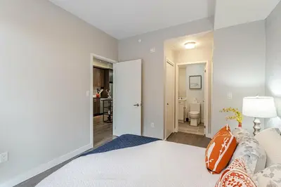 a white bedroom with a bed and a bathroom at 1 BR Boutique Charm, Urban Calm! in Oakville