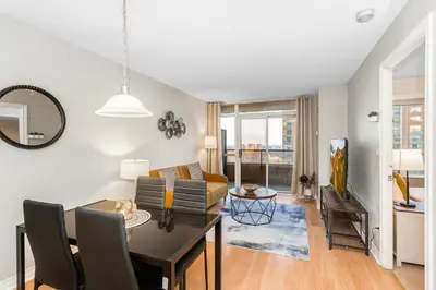 a living room and dining room with a table and chairs at High-Rise Skyline Suite Sleeps 5 Steps to SQ1 in Mississauga