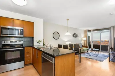 an open kitchen and living room with a couch at High-Rise Skyline Suite Sleeps 5 Steps to SQ1 in Mississauga