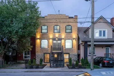 a brick house with lights on the front of it at Renovated Church Hamilton! Sleeps 10 Overnight! in Hamilton