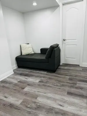 a black couch sitting in a room next to a door at Konia Abode in Orangeville