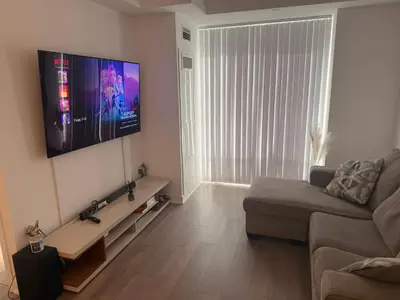 a living room with a couch and a flat screen tv at Uniqueplace in Vaughan