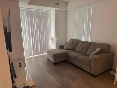 a living room with a couch and a large window at Uniqueplace in Vaughan