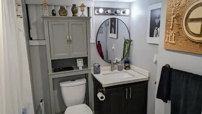 a bathroom with a toilet and a sink and a mirror at Room Ideal for Knowledge Workers in Toronto