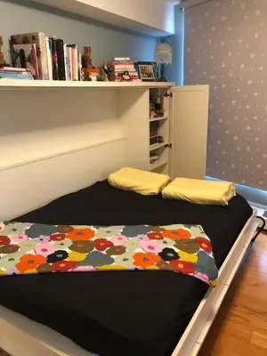 two beds in a room with a book shelf at Hamilton condo, close to Toronto and Niagara Falls in Hamilton