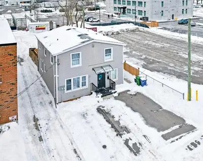 a house is covered in snow in a city at 6BR Family Friendly Retreat, Separate Floors, 5 Minutes Walk to The Fallsview with Free Parking & Wine in Niagara Falls