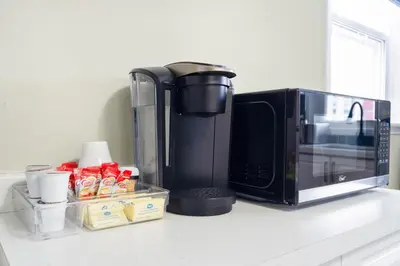 a kitchen counter with a microwave and a coffee maker at 6BR Family Friendly Retreat, Separate Floors, 5 Minutes Walk to The Fallsview with Free Parking & Wine in Niagara Falls