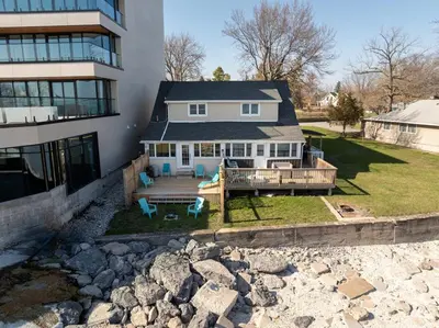 a house with a deck and a building at Crystal Beach Stunning Waterfront Stay with Fire Pit in Fort Erie