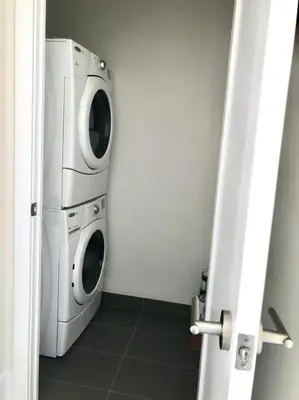 a washer and dryer in a small room at CN Tower and Rogers Centre View and Central Island Lake View in Toronto
