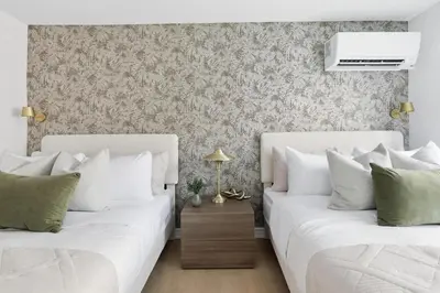 two white beds in a bedroom with a wall at Modern Queen West Retreat Massive Patio 65 TV in Toronto