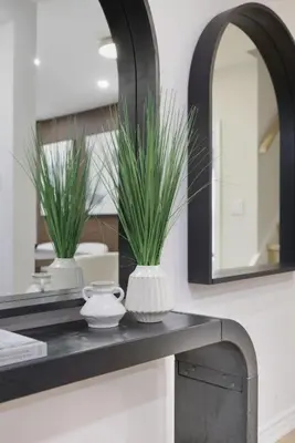 a bathroom counter with a mirror and two plants on it at Modern Queen West Retreat Massive Patio 65 TV in Toronto