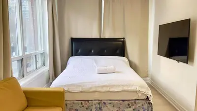 a bedroom with a bed and a couch and a television at warm heart toronto in Toronto
