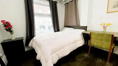 a bedroom with a bed and a desk and a window at warm heart toronto in Toronto