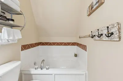 a white bathroom with a tub and a sink at 225 Snowbridge with Village Shuttle in Blue Mountains