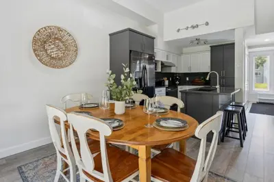 a kitchen and dining room with a wooden table and chairs at Townhouse with Hot Tub near Blue Mountain Village - 162 Vacation Inn in Collingwood