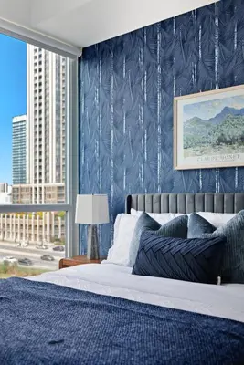 a bedroom with a bed with a blue wall at Sleek Sq 1 Downtown Condo - 4 beds - Parking in Mississauga