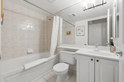 a white bathroom with a toilet and a sink at Tropical Designer King Suite - Sleeps 5 - Parking in Mississauga