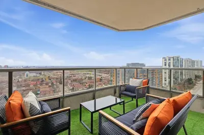 a balcony with chairs and tables and a view of a city at Elegant 2BR Sky Condo for 9 - Terrace - Lake Views in Mississauga