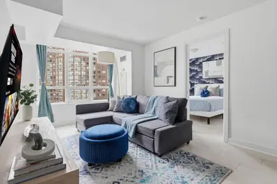 a living room with a couch and a bed at Designer 2BR - King Suite - Rare 2 Parking - YYZ in Mississauga