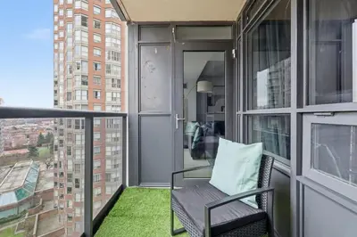 a balcony with a chair and a window at Designer 2BR - King Suite - Rare 2 Parking - YYZ in Mississauga