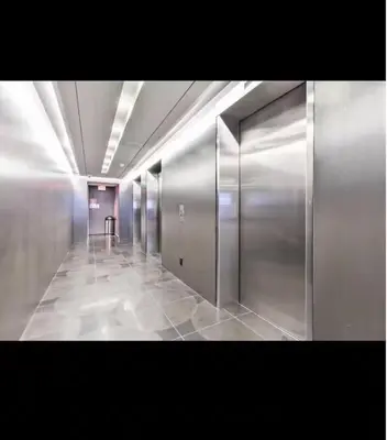 a hallway with silver elevators in a building at The Vicky - Centre of Attention - Location Design in Toronto