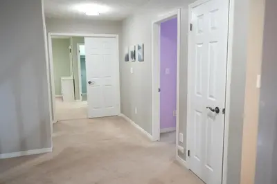 an empty room with white doors and purple walls at Luxury 5BR Home with Spa Bath in Burlington