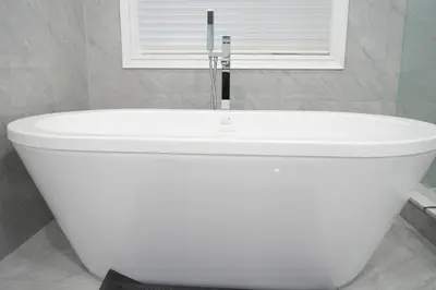 a white bath tub in a bathroom with a window at Luxury 5BR Home with Spa Bath in Burlington