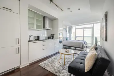 a kitchen and living room with a couch and a table at Lake view Studio Condo High Floor Downtown Toronto in Toronto