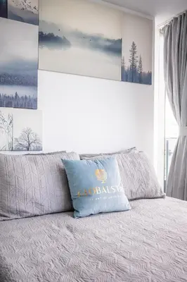 a bed with a blue pillow on top of it at Lake view Studio Condo High Floor Downtown Toronto in Toronto