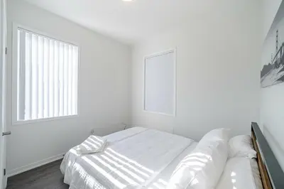 a white bedroom with a bed and a window at Centrally Located 3-Bedroom Townhouse in Vaughan in Vaughan