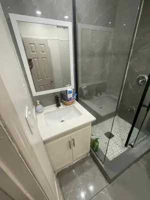 a bathroom with a sink and a shower with a mirror at Cost Effective Stay in Core Downtown Queen-King St-Self Checkin & Free Wifi in Toronto