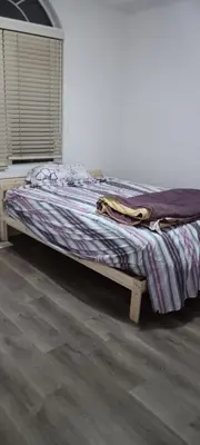 an unmade bed in a room with at House near Toronto Pearson Airport in Brampton