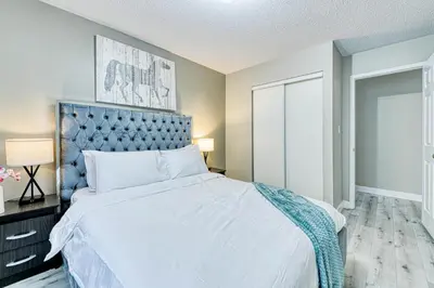 a bedroom with a large bed with a blue headboard at The Urban Family Pad in Toronto