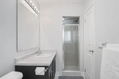 a white bathroom with a sink and a shower at Spacious Toronto Home Near High Park and Yorkdale Mall in Toronto