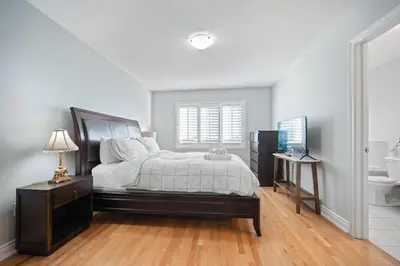 a bedroom with a large bed and a bathroom at Spacious Toronto Home Near High Park and Yorkdale Mall in Toronto