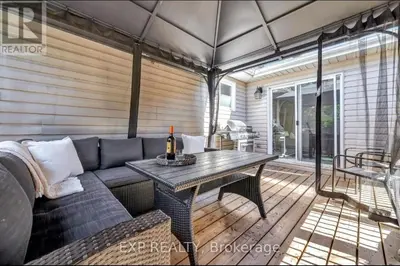 a patio with a couch and a table with a bottle of wine at Luxurious home in Belleville in Belleville