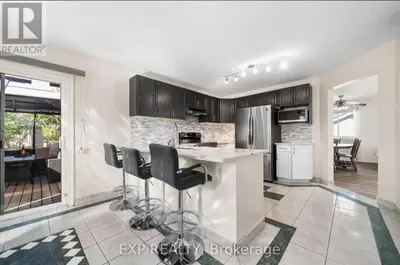 a kitchen with black cabinets and a counter with stools at Luxurious home in Belleville in Belleville