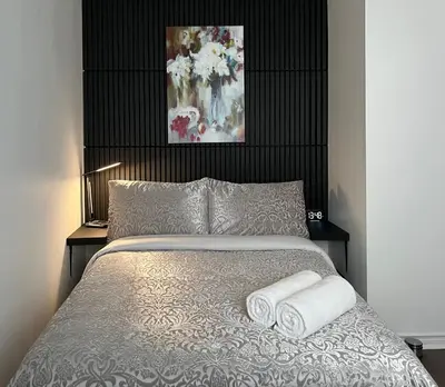 a bedroom with a bed with two towels on it at Private Room with Shared Bathroom in West-Toronto in Toronto