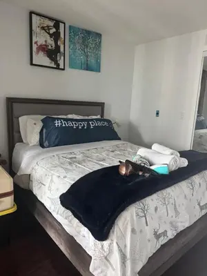 a bed with a black and white blanket and towels at 1 bedroom condo by lakeshore in Toronto