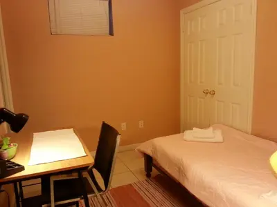 a bedroom with a desk and a bed and a table at Maria's Homestay in Thornhill