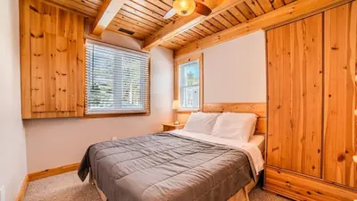 a bedroom with a bed in a room with wooden walls at #90 Lakefront 3-bdrm Chalet in Muskoka in Port Carling