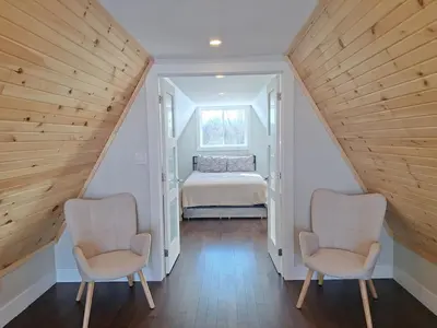 two chairs in a attic room with a bed at Elderado A-Frame