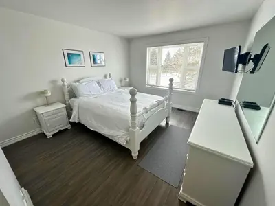 a bedroom with a white bed and a window at Family Townhome with outdoor pool access in Collingwood