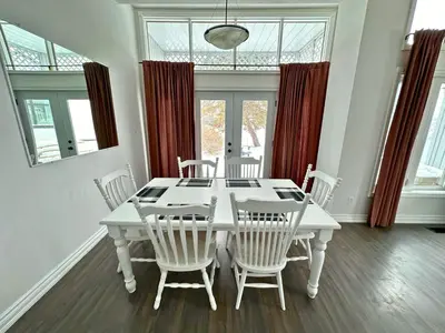 a white dining room with a white table and chairs at Family Townhome with outdoor pool access in Collingwood