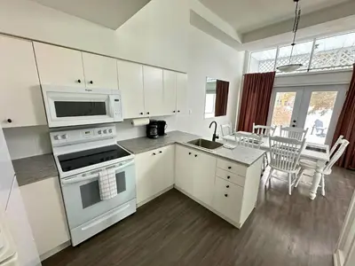 a kitchen with white cabinets and a stove top oven at Family Townhome with outdoor pool access in Collingwood
