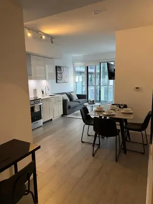 a kitchen and living room with a table and chairs at Luxury Condo Downtown Toronto in Toronto